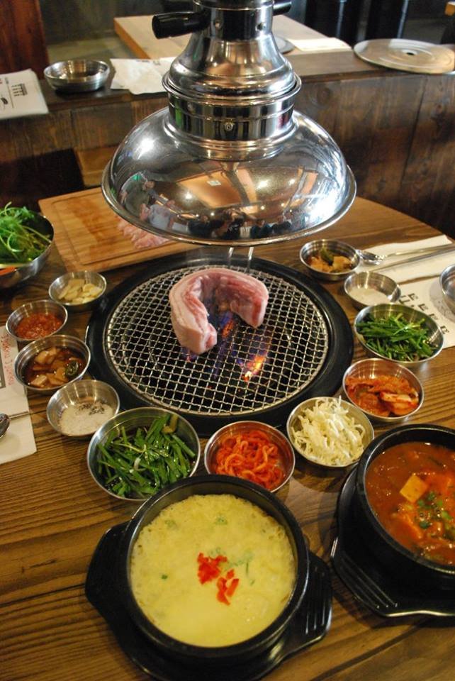 Warm restaurant interior with grill-ready tables.